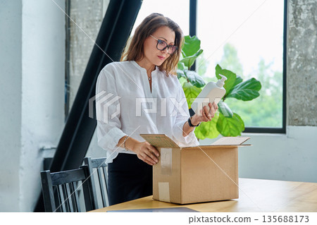 Happy satisfied woman unpacking online purchase, looking at package with cosmetics Happy satisfied woman unpacking online purchase, looking at package with cosmetics 135688173
