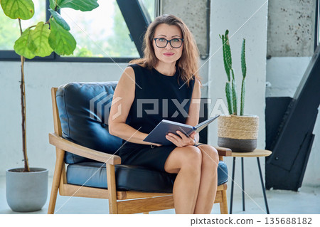 Portrait of businesswoman, psychologist, therapist with business notebook in office 135688182
