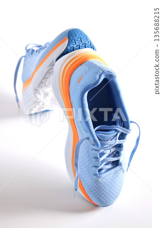 Blue and orange running shoes on white background 135688215