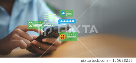 Business person hands using smartphone to give five star rating. Customer satisfaction survey and feedback review concept with pop-up icons for excellent service experience. Business person hands using smartphone to give five star rating. Customer satisfaction survey and feedback review concept with pop-up icons for excellent service experience. 135688235