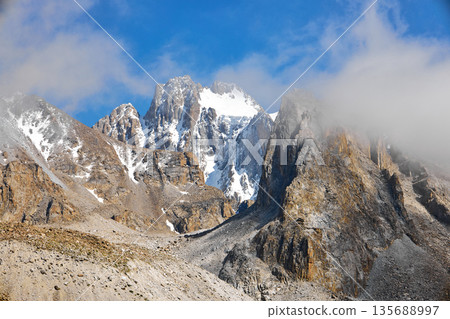 Snow capped rugged mountains of Kyrgyzstan. Majestic landscape Snow capped rugged mountains of Kyrgyzstan. Majestic landscape 135688997