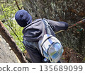 Hiker Climbing Rocky Trail with Backpack 135689099