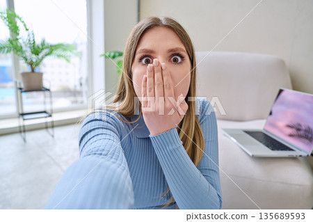 Selfie portrait surprised shocked young woman in home interior 135689593