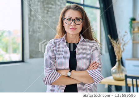 Portrait of middle-aged confident business woman looking at camera Portrait of middle-aged confident business woman looking at camera 135689596