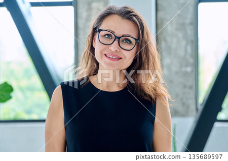 Headshot portrait of smiling middle aged businesswoman with glasses Headshot portrait of smiling middle aged businesswoman with glasses 135689597