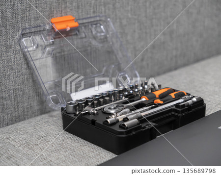 Open tool kit displaying metal wrenches, screwdriver bits, and an orange-handled screwdriver, symbolizing essential equipment for home improvement and technical repair 135689798