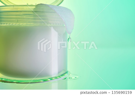 Skincare product jar with liquid drop and cotton pad 135690159