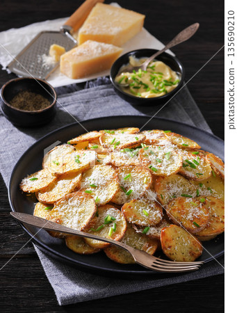 Roasted Potato Slices with Parmesan Cheese Top View Roasted Potato Slices with Parmesan Cheese Top View 135690210