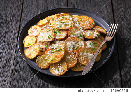 Roasted Potato Slices with Parmesan Cheese Top View Roasted Potato Slices with Parmesan Cheese Top View 135690216
