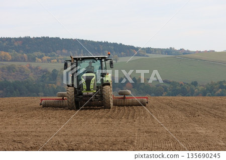 Tractor is cultivating the soil 135690245