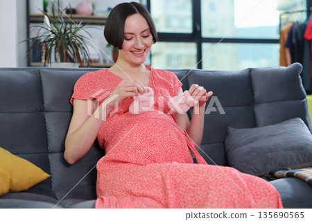 Expecting joy with handmade baby booties during a bright afternoon at home Expecting joy with handmade baby booties during a bright afternoon at home 135690565
