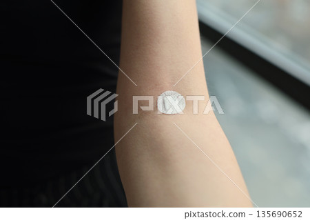 Applying a skincare treatment to the skin, ensuring hydration and care for healthy skin on a sunny day indoors 135690652