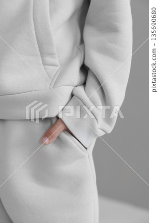 Gray hooded sweatsuit with pockets and cuffs. Close-up of the warm sleeve of a tracksuit. Gray hooded sweatsuit with pockets and cuffs. Close-up of the warm sleeve of a tracksuit. 135690680