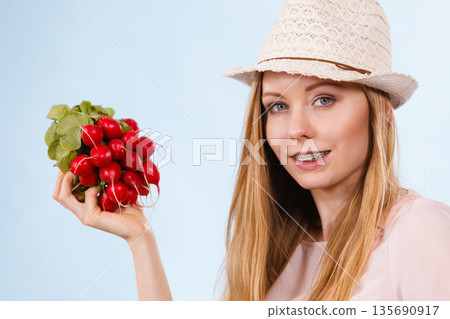 Happy woman holding radish Happy woman holding radish 135690917