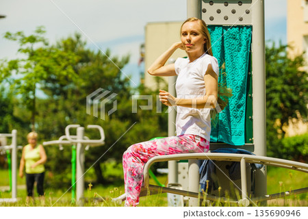 Girl doing situps in outdoor gym 135690946