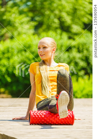 Girl doing exercises outdoor, using roller Girl doing exercises outdoor, using roller 135690954
