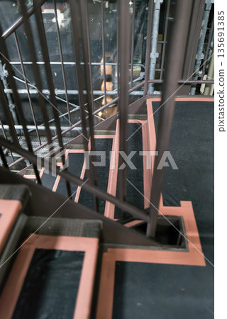 Scaffolding for repairing the exterior walls of an apartment building. Mesh sheet through which the night view can be seen. Construction site background material. 135691385