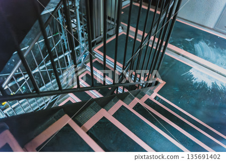 Scaffolding for repairing the exterior walls of an apartment building. Mesh sheet through which the night view can be seen. Construction site background material. Scaffolding for repairing the exterior walls of an apartment building. Mesh sheet through which the night view can be seen. Construction site background material. 135691402