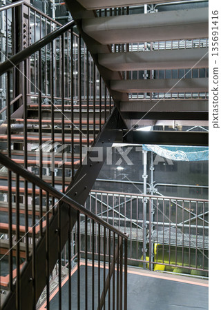 公寓翻修工程的鷹架走道,安全網和鐵管,建築背景 公寓翻修工程的鷹架走道,安全網和鐵管,建築背景 135691416