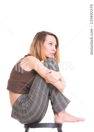 worried and afraid young woman sitting on chair. Isolated worried and afraid young woman sitting on chair. Isolated 135692374