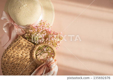 Straw Hat with Pink Ribbon on Pink Background. Romantic Spring Summer Flatlay on Peach Background 135692876