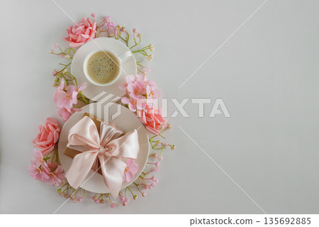 Coffee Cups, Gift Box and Pink Flowers in Shape of Eight. Elegant Flatlay for International Womens Day Coffee Cups, Gift Box and Pink Flowers in Shape of Eight. Elegant Flatlay for International Womens Day 135692885
