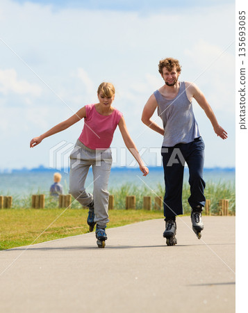 Teen couple together on skates. 135693085