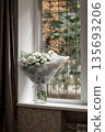 White carnation bouquet on a windowsill with autumn view 135693206