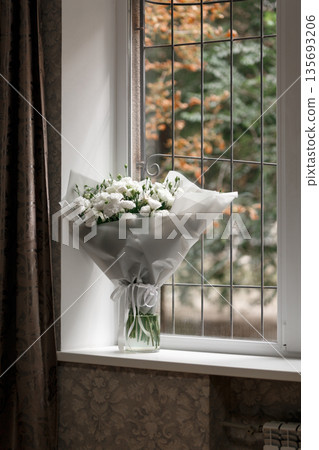 White carnation bouquet on a windowsill with autumn view White carnation bouquet on a windowsill with autumn view 135693206