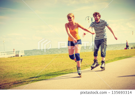 Young couple on roller skates riding outdoors 135693314