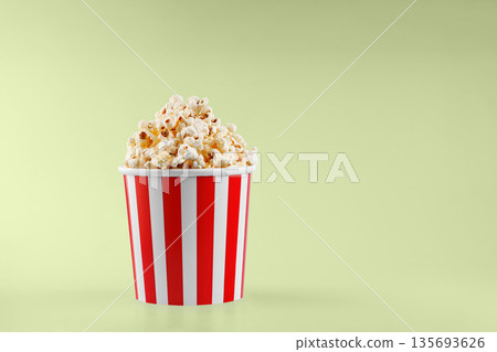 Classic red striped popcorn cardboard cup on Green background Classic red striped popcorn cardboard cup on Green background 135693626