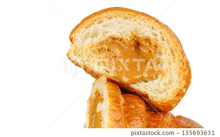 Sliced croissant with caramel condensed milk filling isolated on white. Tasty sweet French pastry. 135693631
