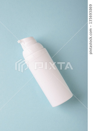 Hydrating cosmetic bottle with water drops on blue background Hydrating cosmetic bottle with water drops on blue background 135693869