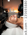 Senior woman receiving professional RF lifting facial treatment focused on skin tightening and age-related skincare. 135693880