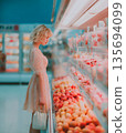 Woman Browsing Fresh Produce in a Supermarket Aisle 135694099