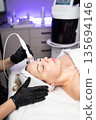 Professional facial RF lifting procedure performed by a cosmetologist using modern radiofrequency equipment in a beauty clinic. 135694146