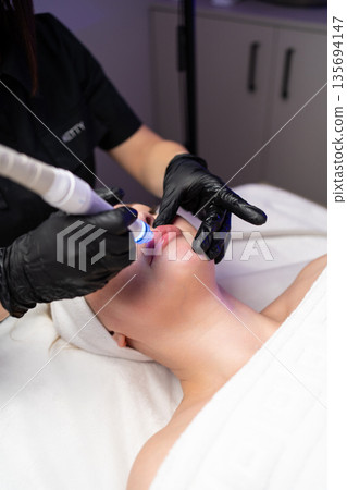 Close-up of cosmetology hardware treatment focused on healthy glowing skin and anti-aging care. 135694147