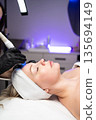 Woman receiving noninvasive facial procedure for skin rejuvenation and deep cleansing in a medical spa. 135694149