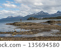 Hiker standing on rocky outcrop in vast Beagle Channel, Tierra del Fuego 135694580