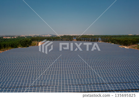 Solar power plant surrounded by green landscape Solar power plant surrounded by green landscape 135695825