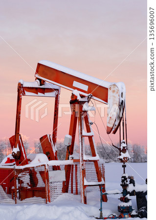 Snow Covered Oil Pumpjack at Winter Sunrise Snow Covered Oil Pumpjack at Winter Sunrise 135696007