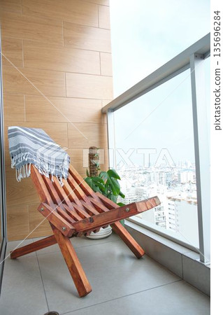 Cozy balcony with wooden chair and city skyline view 135696284
