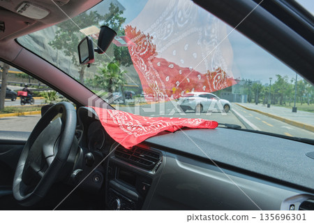 Car interior red bandana reflecting on windshield Car interior red bandana reflecting on windshield 135696301