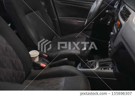 Car interior with coffee cup on center console Car interior with coffee cup on center console 135696307