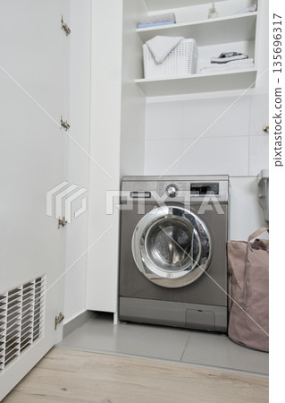 Washing machine in domestic laundry room producing clean clothes Washing machine in domestic laundry room producing clean clothes 135696317