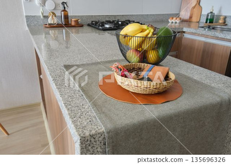 Kitchen island with fruit basket and decorative items 135696326