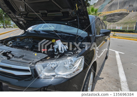 Car breakdown with hood open inspecting engine Car breakdown with hood open inspecting engine 135696384