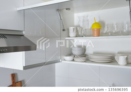 Modern white kitchen interior with open cabinet and shelves 135696395