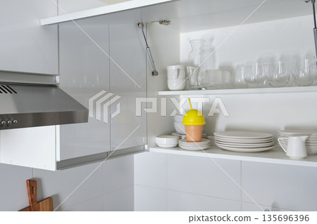 Modern kitchen corner with white cabinets and dishes 135696396