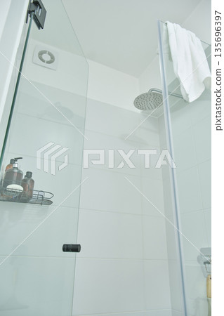 Modern bathroom shower with glass door and toiletries Modern bathroom shower with glass door and toiletries 135696397